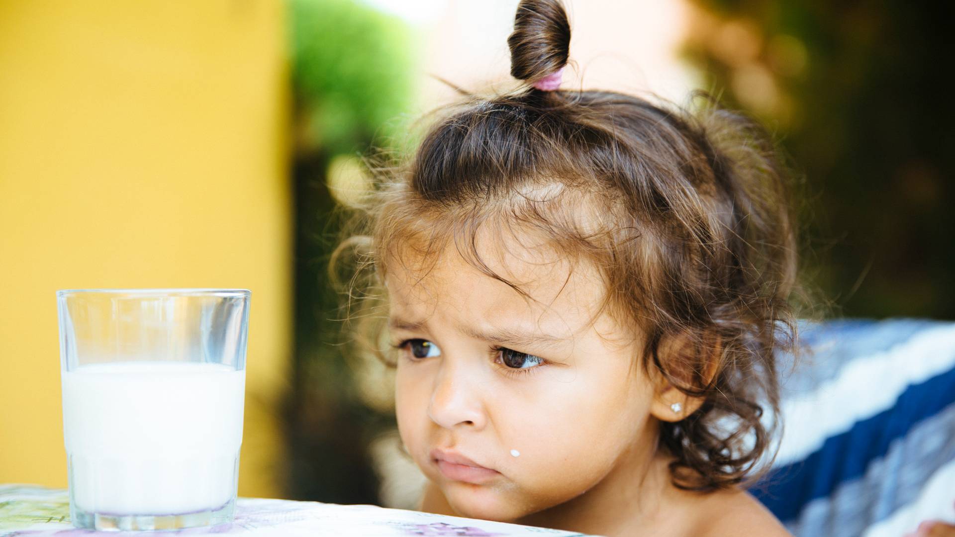 unhappy child stares at milk