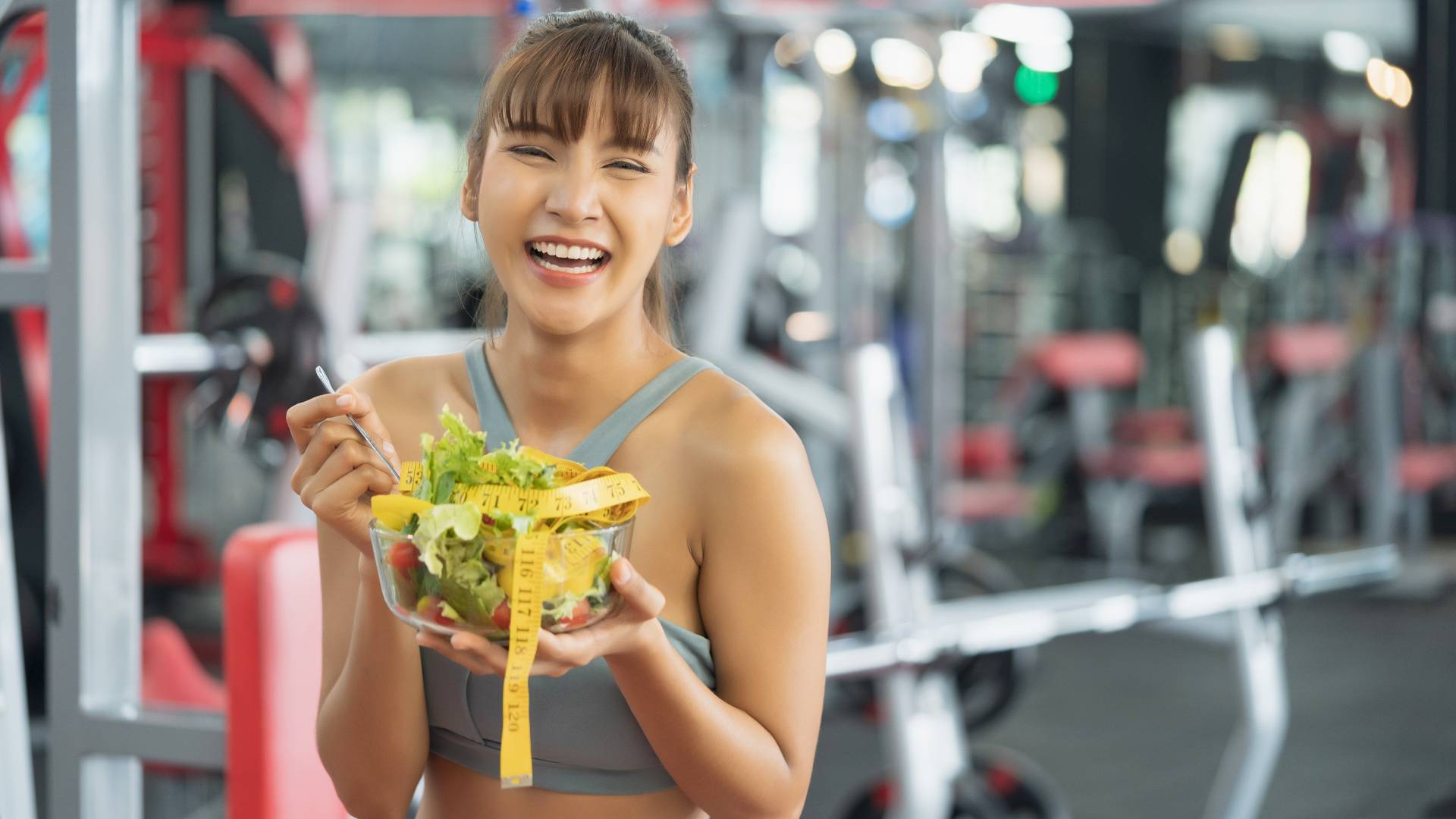 woman eating salad at gym