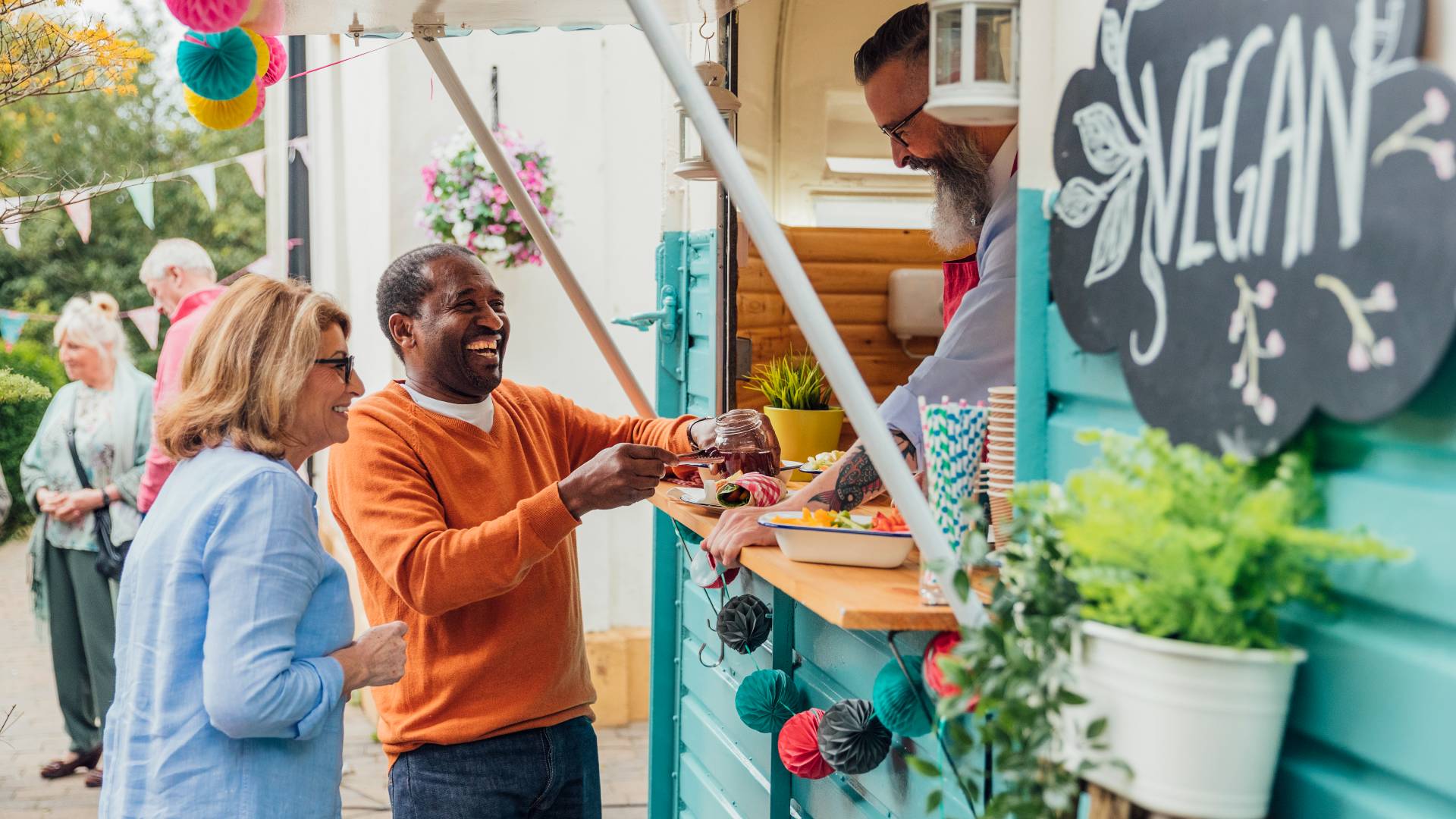 adult couple buying lunch from vegan food truck