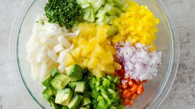 En un tazón grande, mezclar la jícama, los pimientos morrones, la cebolla, el pepino, la naranja, el aguacate (si usa) y el cilantro.