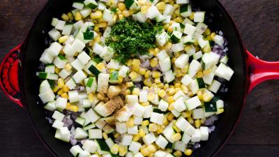 Calentar el 1/4 taza de caldo restante en una sartén grande a fuego medio. Agregar la cebolla y saltear durante 5 minutos. Agregar el calabacín y el maíz y saltear durante 3 minutos. Agregar el comino y el cilantro y saltear durante 1 minuto. Condimentar con sal y pimienta negra.