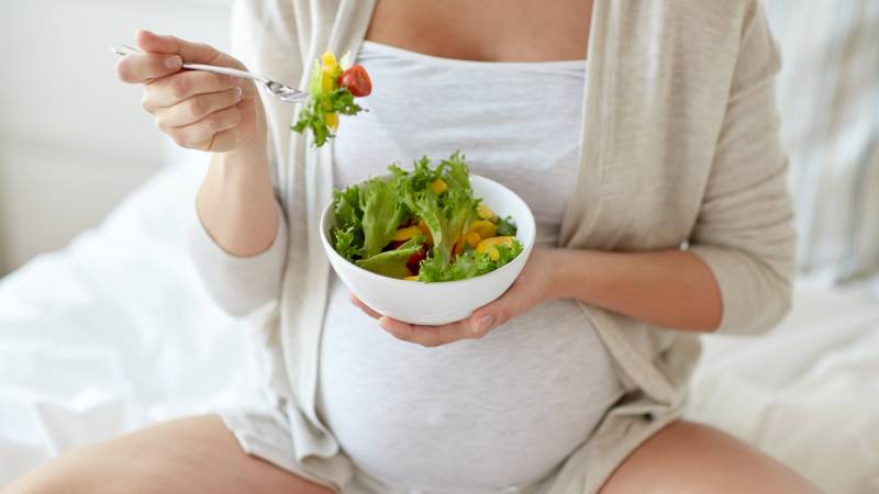 pregnant woman eating a salad