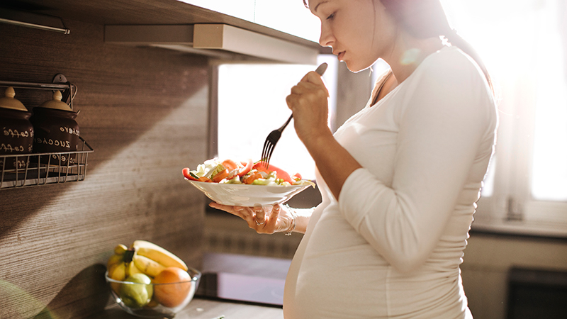 expecting woman eating salad